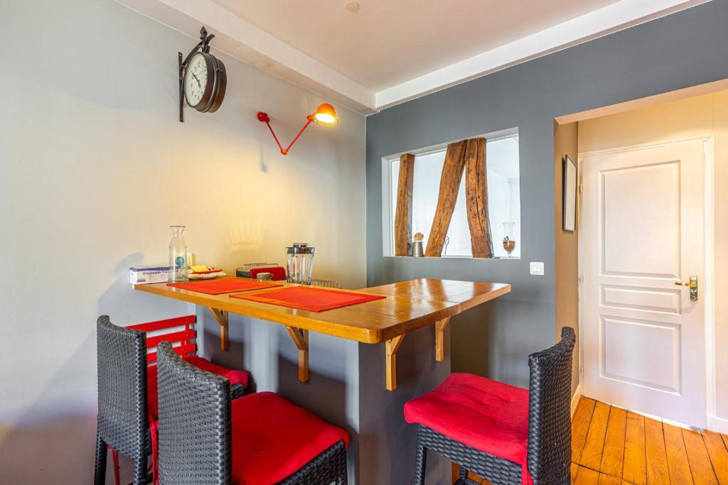 jadalnia z drewnianym stołem i czerwonymi krzesłami w obiekcie GuestReady - Amazing stay in the 19th arr. w Paryżu