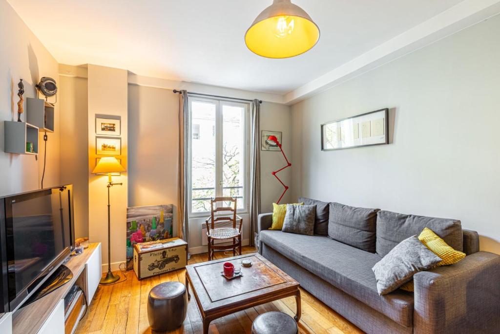salon z kanapą i telewizorem w obiekcie GuestReady - Amazing stay in the 19th arr. w Paryżu