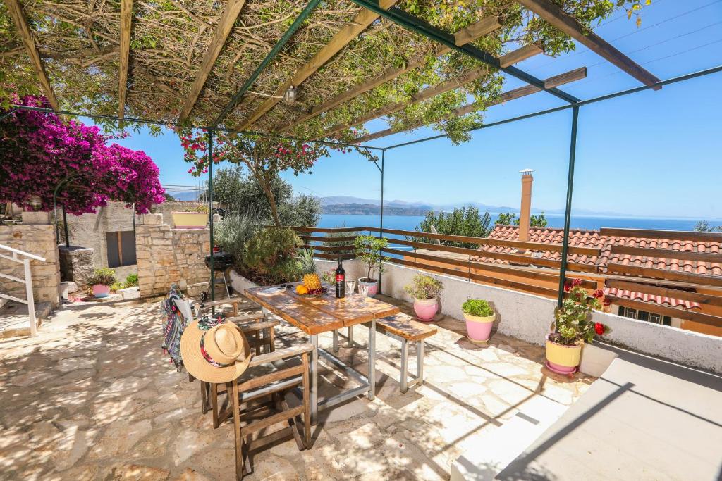 patio ze stołem i krzesłami oraz widokiem na ocean w obiekcie Joannas Sea-View Stone House w mieście Katávolos