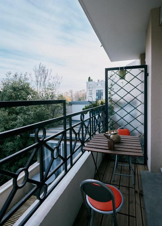 d'un balcon avec une table en bois et deux chaises. dans l'établissement GuestReady - Cosy Stay for 3 in Meudon, à Meudon