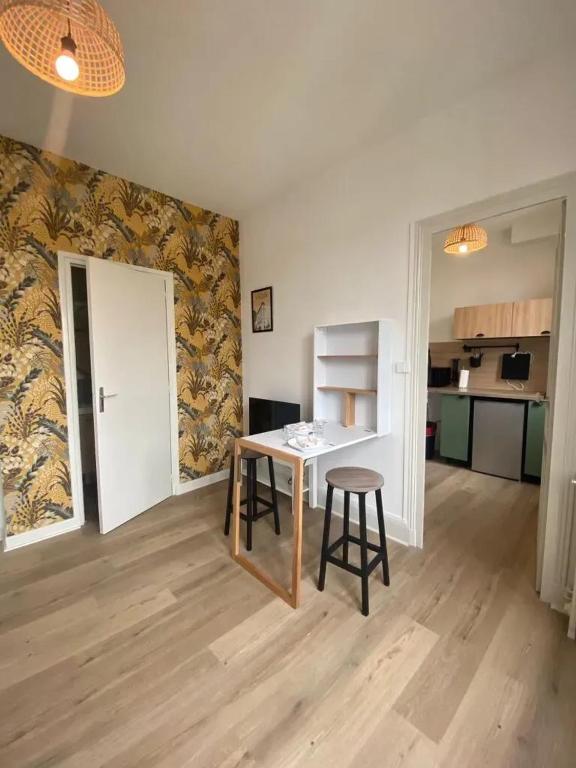 un salon avec une table et une cuisine dans l'établissement Appartement cosy centre-ville Vichy, 23 m², proche thermes, à Vichy