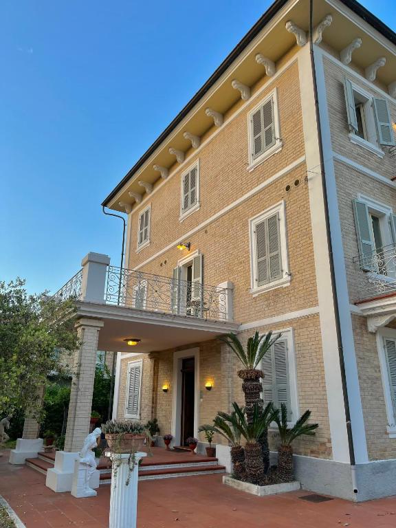 a large brick building with a balcony on top at Villa Francesca Luxury - Adriatic Nature & Heritage House in Grottammare