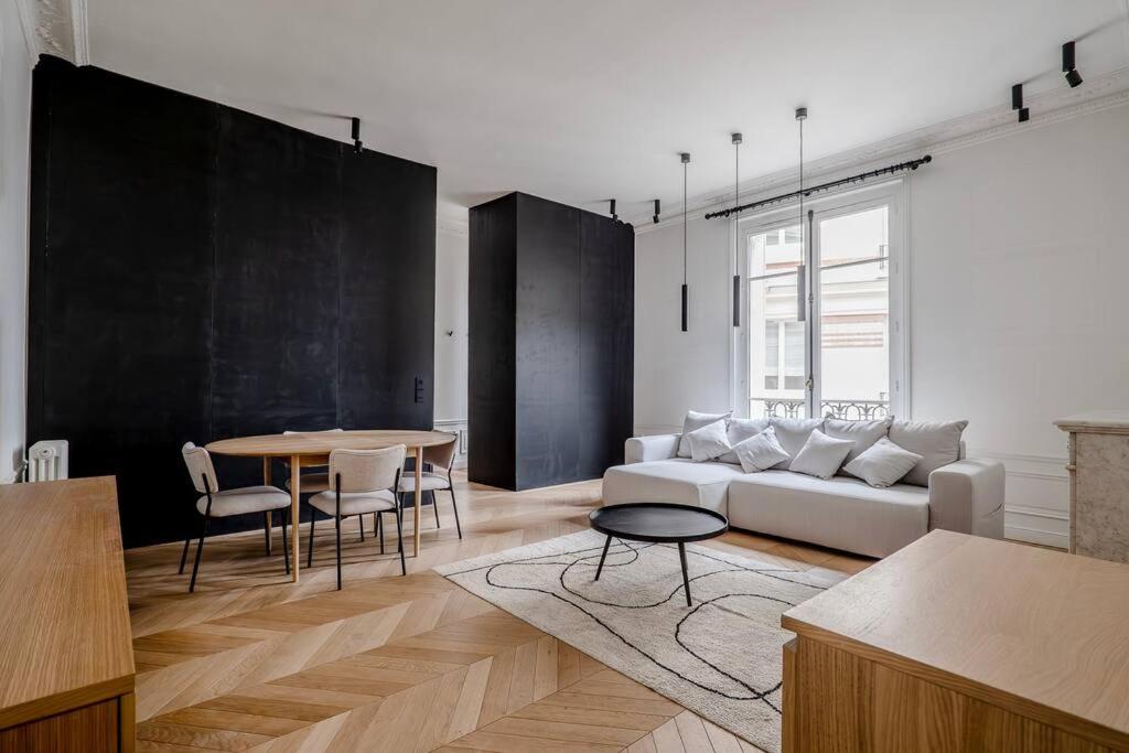 un salon avec un canapé blanc et une table dans l'établissement GoodGuest- Luxe Stade Tour Eiffel 2BDR, à Paris