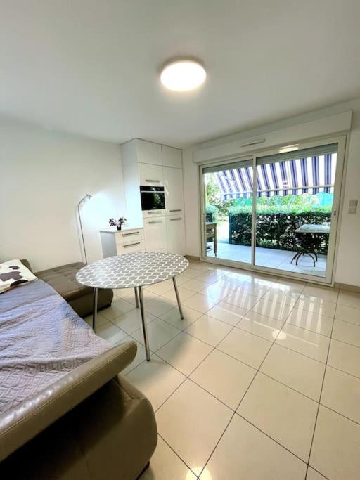 une pièce avec un lit et une table dedans dans l'établissement Jolie Appartement de Bord de la Mer Côte d'Azur, à Roquebrune-Cap-Martin