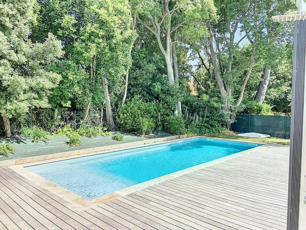 - une piscine dans une cour avec une terrasse en bois dans l'établissement Appartement Standing avec Terrasse, Piscine et Accès Plage, 2 Chambres, Climatisé, Parking, PMR - FR-1-770-28, à Saint-Cyr-sur-Mer