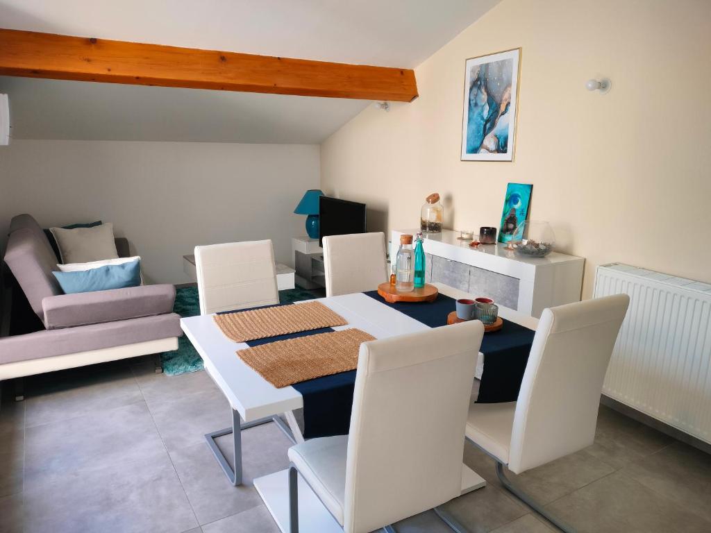une salle à manger avec une table et des chaises blanches dans l'établissement Appartement T3 de prestige Toulon Cap Brun - proche de la plage, à Toulon