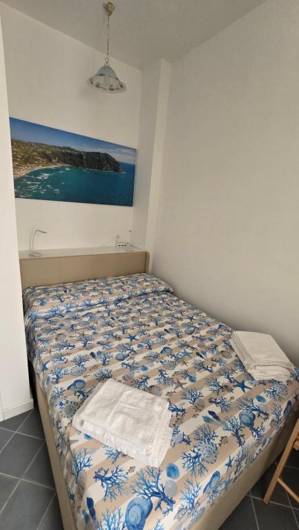 a bed in a room with a painting on the wall at La casa di Giuliana piano terra con cucina e lavatrice in Ischia
