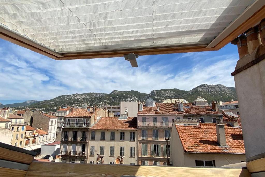 une vue d'une ville depuis la fenêtre d'un immeuble dans l'établissement Cozy apartment close to the sea, à Toulon