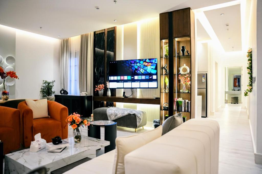 a living room with a couch and a tv at Luxury Smart Apartment E12 in Riyadh