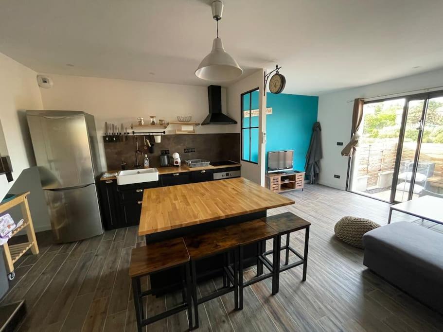 a kitchen with a wooden table in a room at Maison de village avec terrasse in Valensole