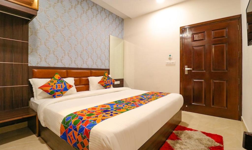 a bedroom with a large bed and a wooden door at Hotel California Heights in Amritsar