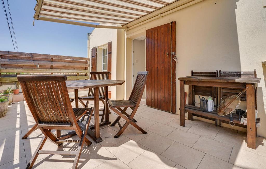 une table et des chaises sur une terrasse avec une cheminée dans l'établissement Charmante maison entre centre ville et mer, à La Rochelle