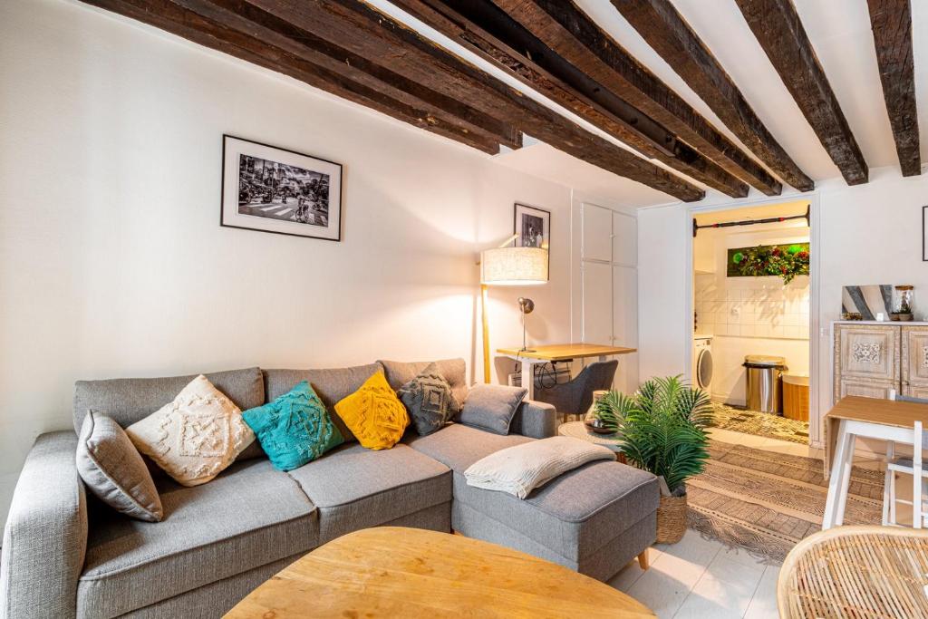 un salon avec un canapé et une table dans l'établissement GuestReady - Exposed beams flat near Le Marais, à Paris
