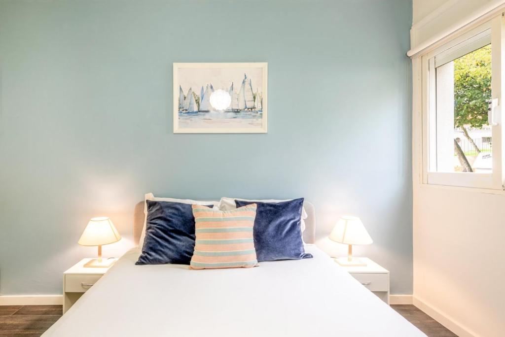 a bedroom with a white bed with two lamps at GuestReady - Great 3BDR apartment in Oeiras! in Oeiras