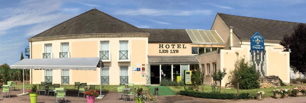 a building with a sign that reads hotel les us at Aux Lys de Chablis in Chablis