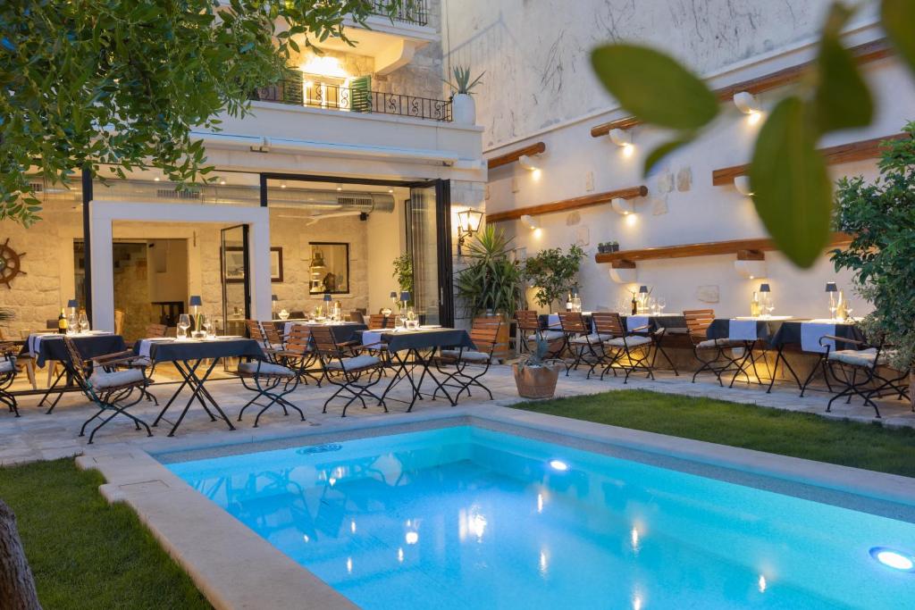 a pool in a courtyard with tables and chairs at NEW - Casa Columba - 4 Star Design Boutique Hotel with Outdoor Pool & Private Garden in Makarska