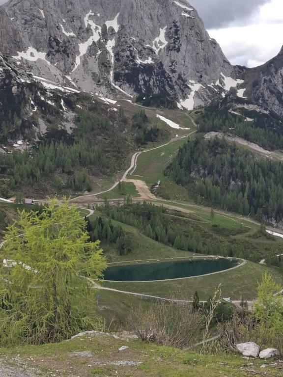 a view of a mountain range with a lake at Nassfeldpass Pistenblick in Sonnenalpe Nassfeld