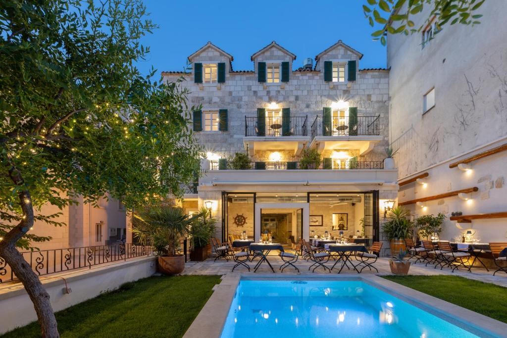 an estate with a swimming pool in front of a building at NEW - Casa Columba - 4 Star Design Boutique Hotel with Outdoor Pool & Private Garden in Makarska