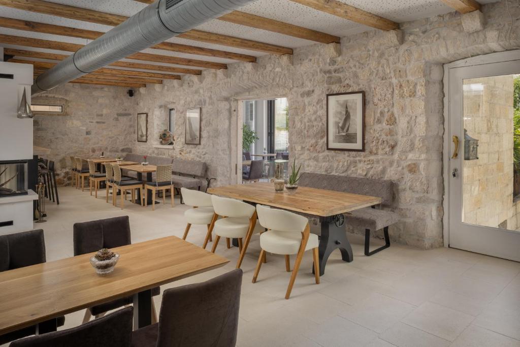 a dining room with wooden tables and chairs at NEW - Casa Columba - 4 Star Design Boutique Hotel with Outdoor Pool & Private Garden in Makarska