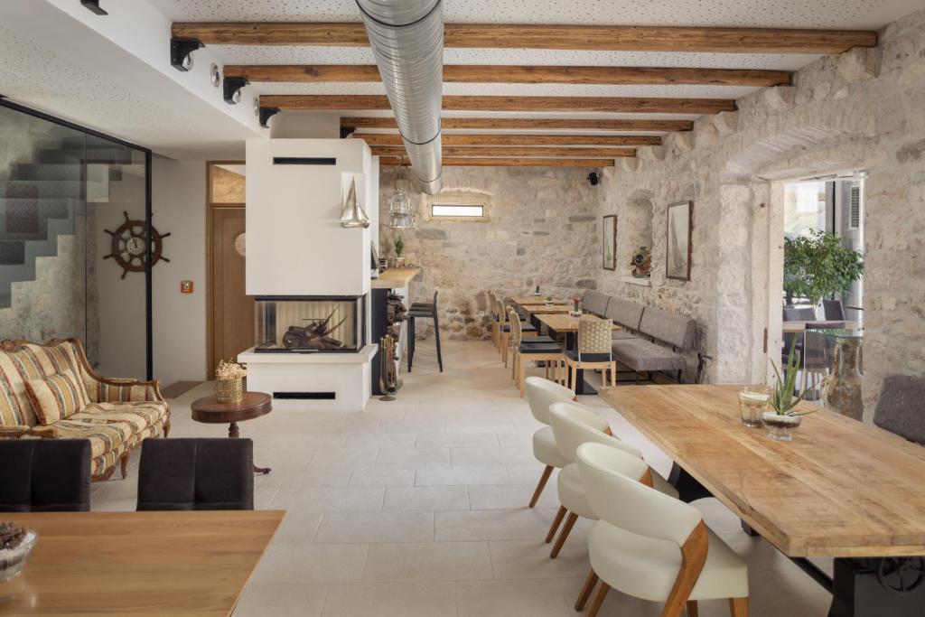a living room with a table and chairs and a fireplace at NEW - Casa Columba - 4 Star Design Boutique Hotel with Outdoor Pool & Private Garden in Makarska