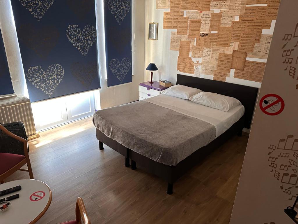 a bedroom with a bed and two large windows at Chambre musicale in Brussels