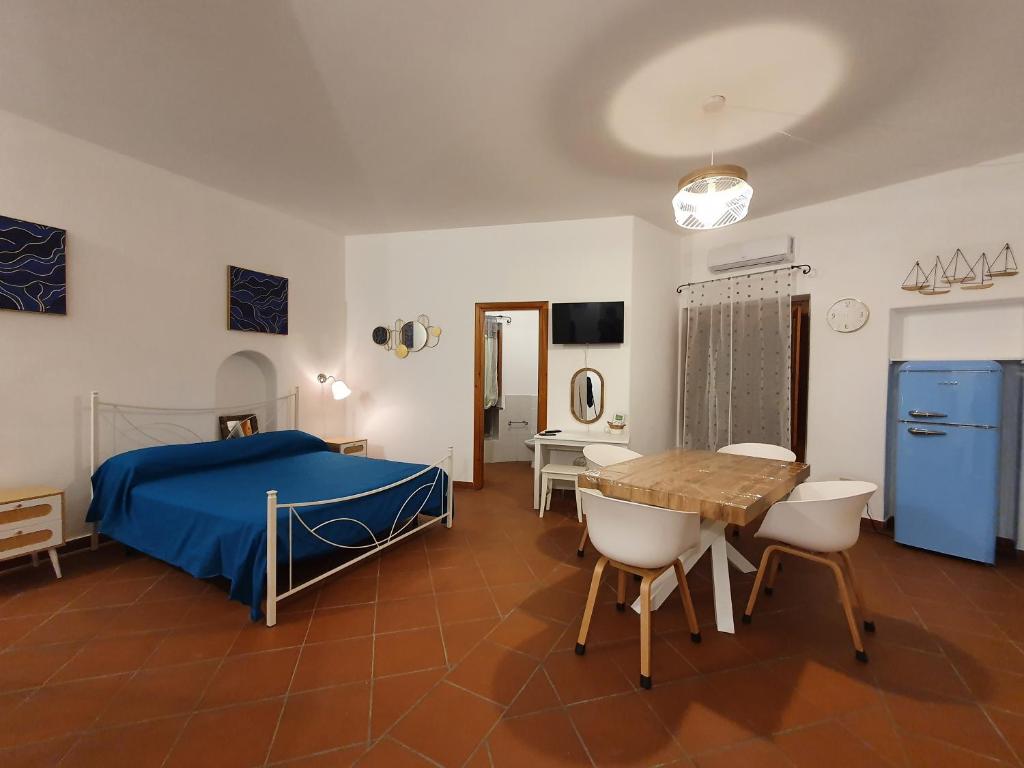 una camera da letto con un letto, un tavolo e delle sedie di Casa Lavinia - open space con terrazza privata a Città di Lipari