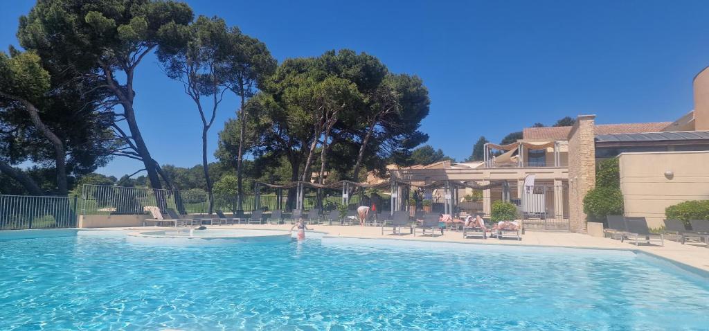 une piscine devant une maison dans l'établissement Appartement sur golf de L'Isle-Sur-La-Sorgue, à Saumane-de-Vaucluse
