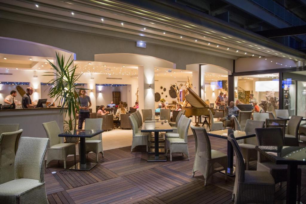 a restaurant with tables and chairs and a piano at Hôtel Campo Dell'oro in Ajaccio