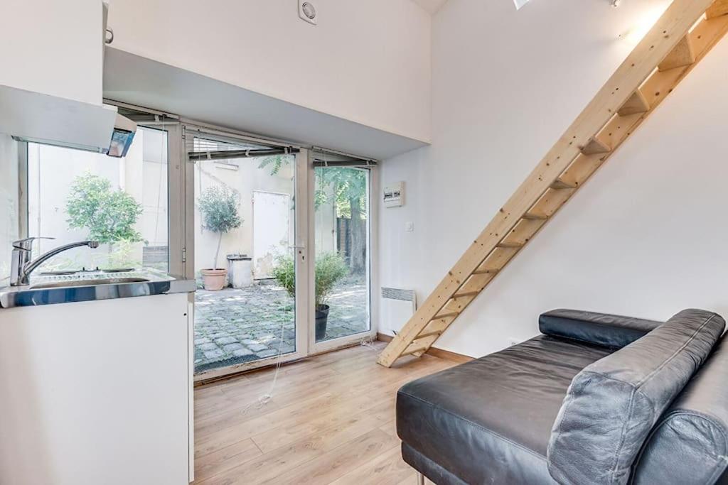 un salon avec un canapé et une cuisine dans l'établissement Studio Butte-Aux-Cailles, à Paris