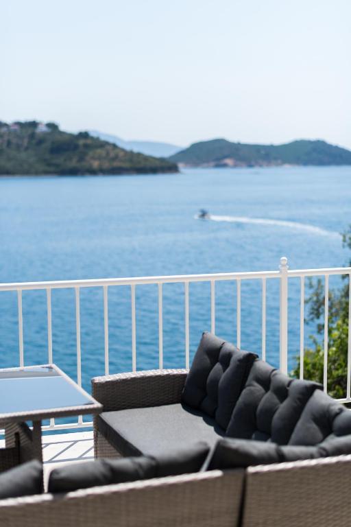 a balcony with a couch and a table and water at Para Thin Alos Skiathos in Skiathos