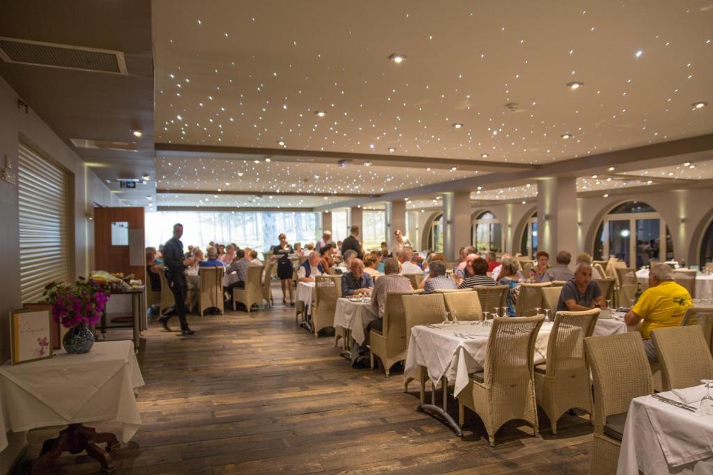 a dining room with people sitting at tables at Hôtel Campo Dell'oro in Ajaccio