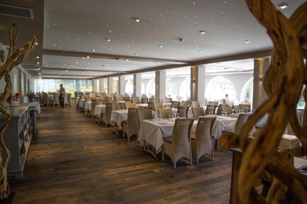 a dining room with white tables and chairs at Hôtel Campo Dell'oro in Ajaccio