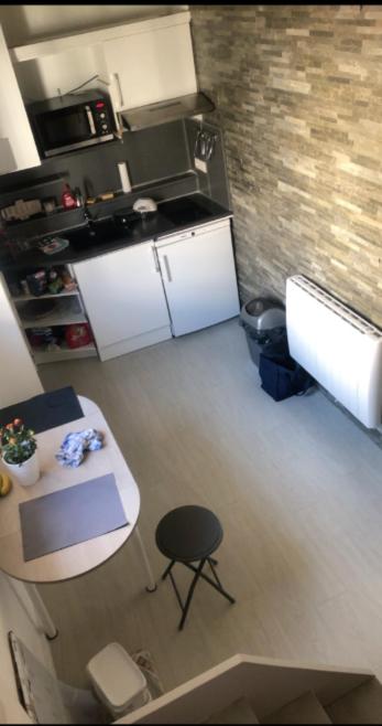 - une vue de tête sur une cuisine avec une table et un comptoir dans l'établissement appartement proche centre ville, à Nice