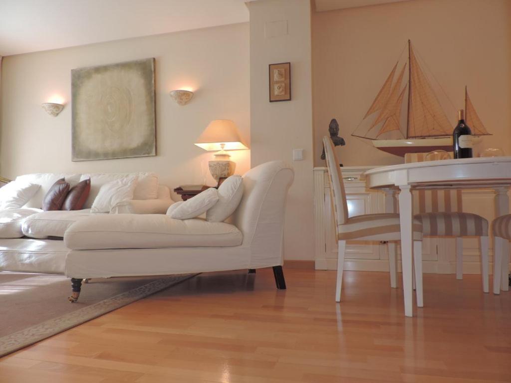 sala de estar con sofá blanco y mesa en Retiro Apartment, en Madrid