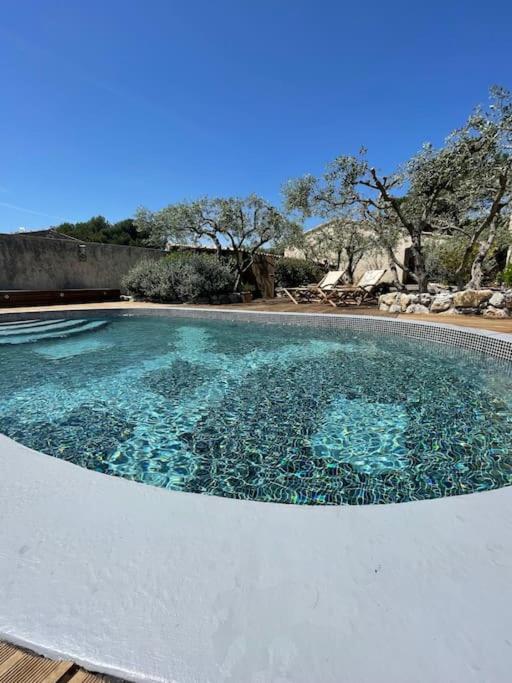 une grande piscine d'eau bleu clair dans l'établissement Maison chaleureuse avec piscine, à Mérindol