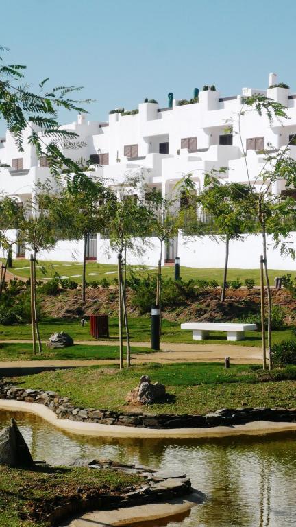 a large white building in the background of a park at Mar de Pulpí Costa de Almeria by Mar Holidays in San Juan de los Terreros