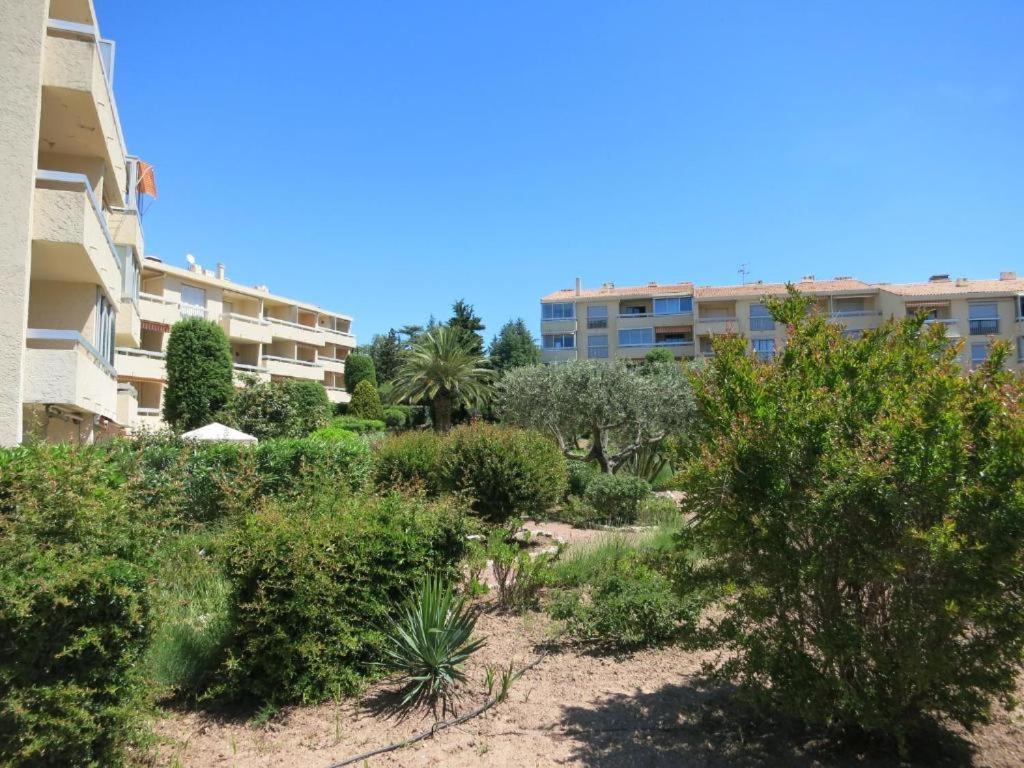 un jardin en face d'un immeuble dans l'établissement LES GABIANS - Appartement T2 - TIKI PLAGE - Saint Raphaël, à Saint-Raphaël