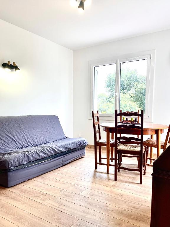 une chambre avec un lit, une table et des chaises dans l'établissement Joli T2 dans une petite résidence calme, à Fréjus