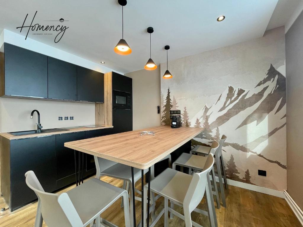 une cuisine avec une table et des chaises et une fresque de montagne dans l'établissement Homency - Résidence Kandahar 20, à L'Alpe-d'Huez