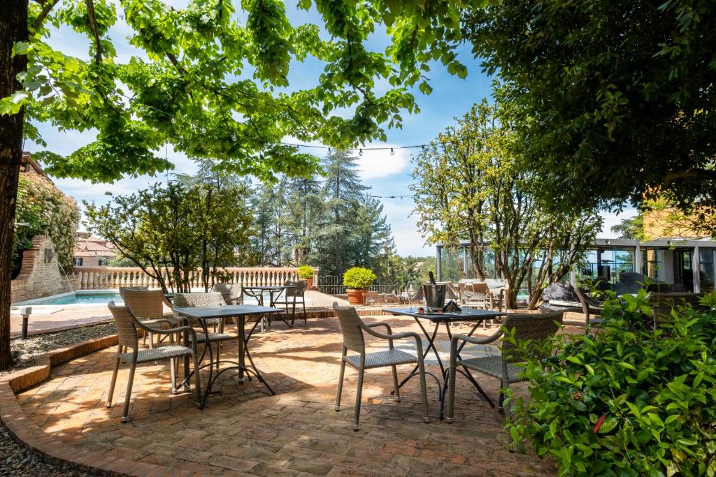 a patio with tables and chairs in a yard at Hotel Vannucci in Citt&agrave; della Pieve