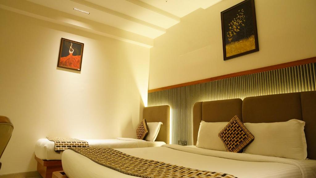 Postel nebo postele na pokoji v ubytování Hotel Ganpati Palace Shirdi Newly Renovated