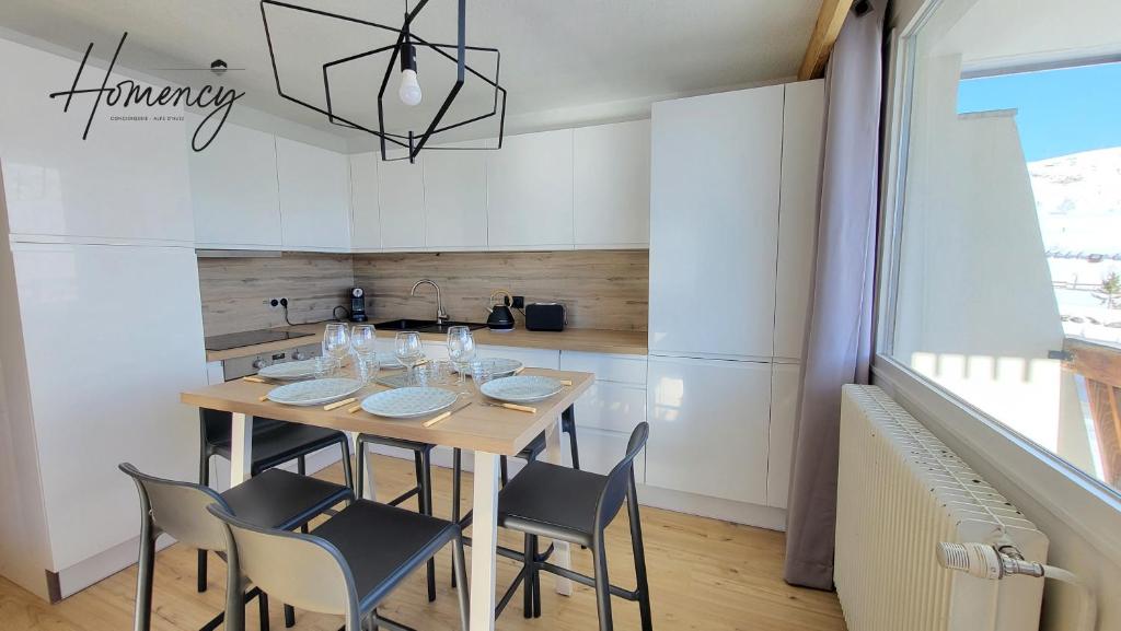 une salle à manger avec une table et des chaises en bois dans l'établissement Homency - Résidence Kandahar 10, à L'Alpe-d'Huez