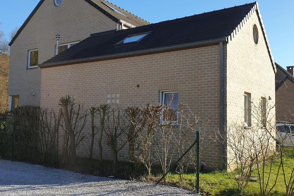un grand bâtiment en briques avec un toit noir dans l'établissement A louer un appart dans une résidence calme, à Mont-Saint-Guibert