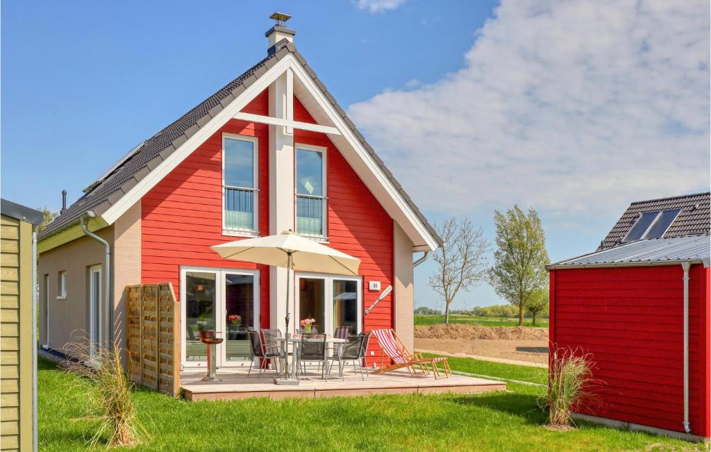 una casa roja con una mesa y una sombrilla en Heimathafen, en Büsum