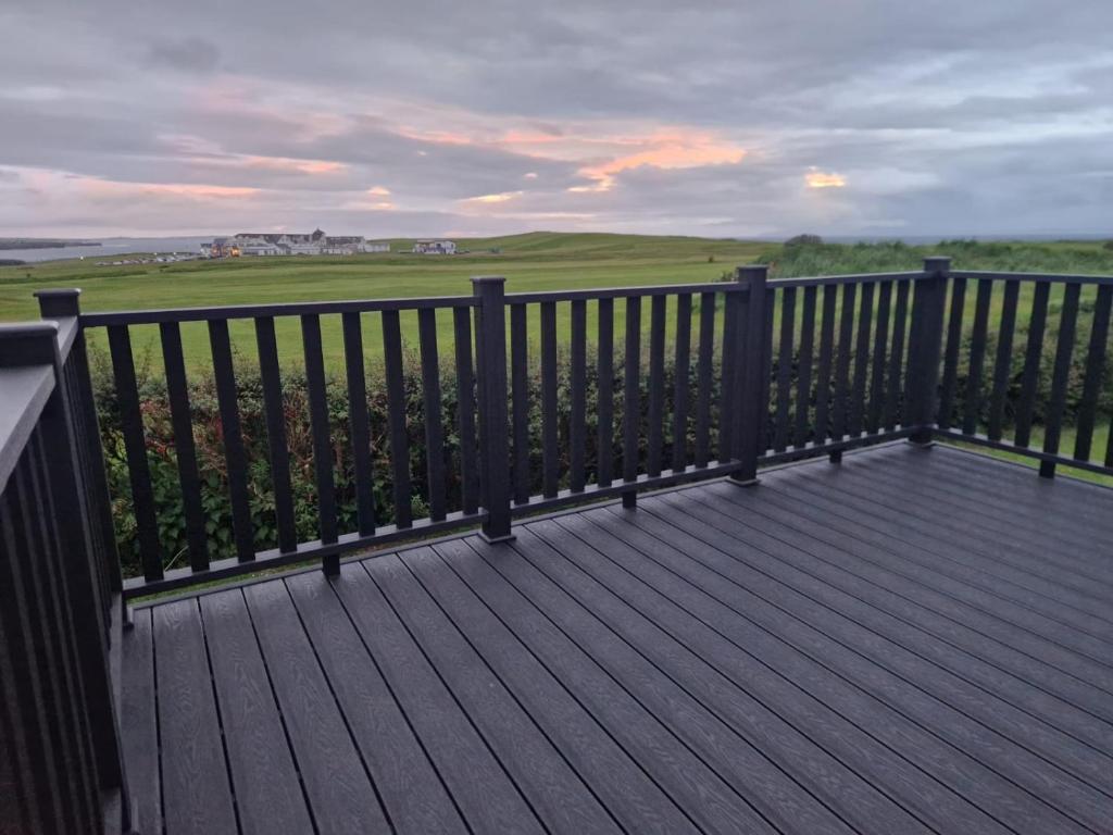 a wooden deck with a view of a green field at 9 Tullan Strand, Bundoran in Bundoran