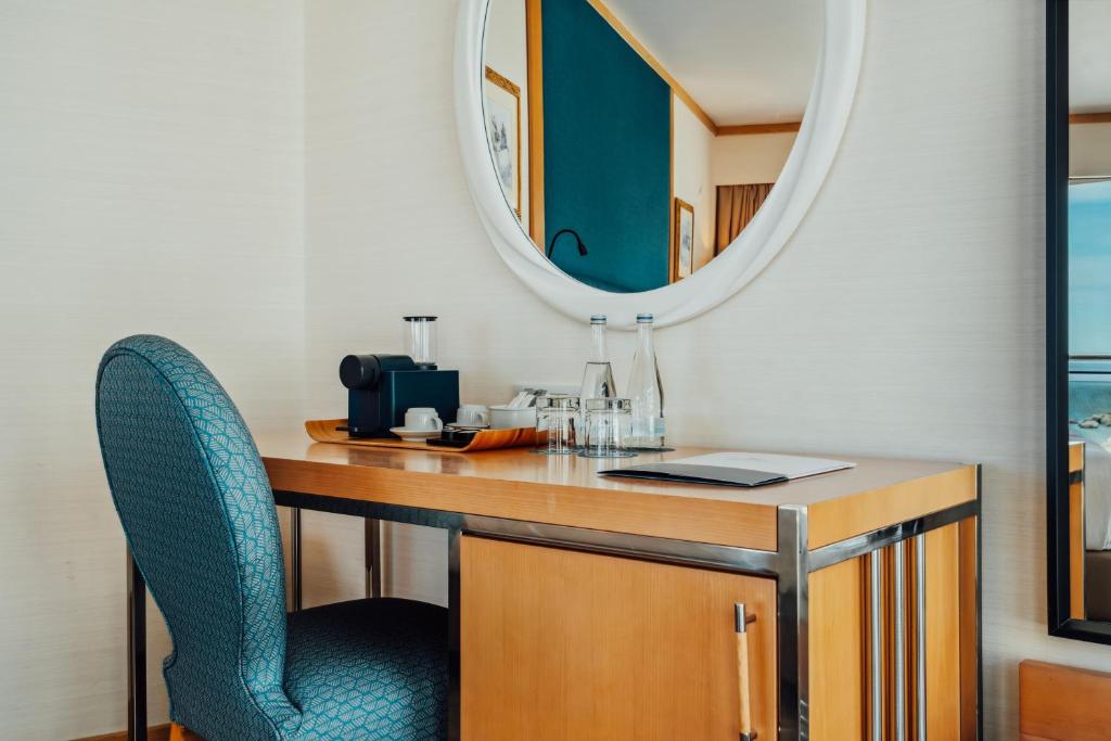 een bureau met een stoel en een spiegel bij Sesimbra Oceanfront Hotel - Preferred Hotels and Resorts in Sesimbra