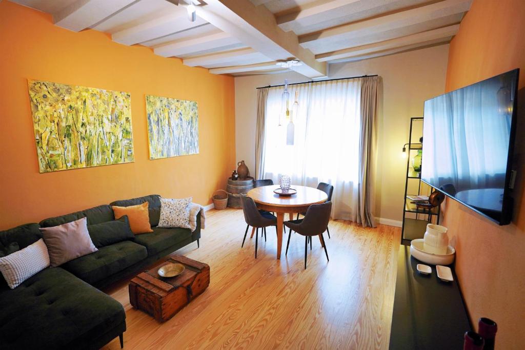 een woonkamer met een groene bank en een tafel bij Winzerhaus am Kardinalsberg in Bernkastel-Kues