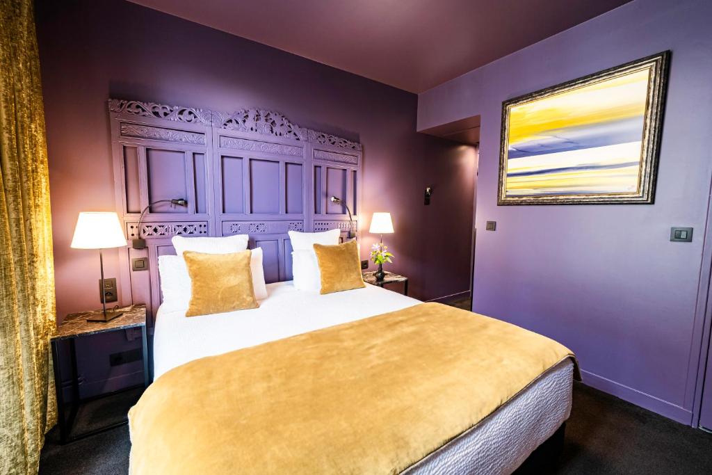 a bedroom with a king sized bed with purple walls at Hotel Villa Nicolo - Tour Eiffel in Paris