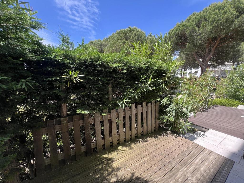 une clôture en bois à côté d'une passerelle en bois dans l'établissement Sol-y-Days Soleiade, Agréable Rez De Jardin proche des plages, à La Grande Motte