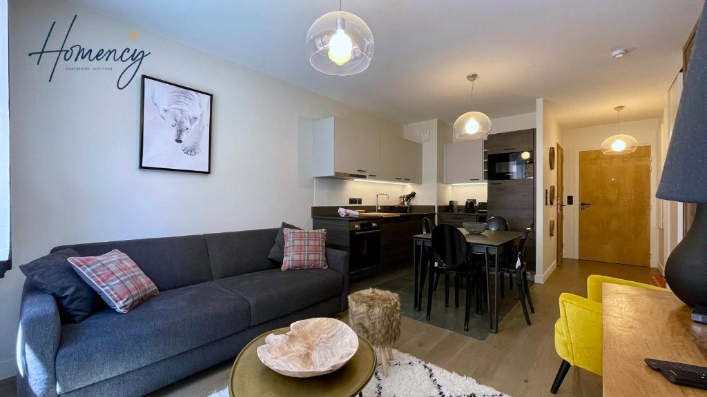 ein Wohnzimmer mit Couch und Küche in der Unterkunft Homency - Résidence Fermes de l'Alpe A003 in L'Alpe-d'Huez